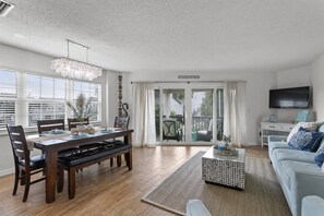 A modern living room with a dining area, a sofa, and a TV. - BEACH AND INTERCOASTAL ACCESS!!  (Indian Shores)