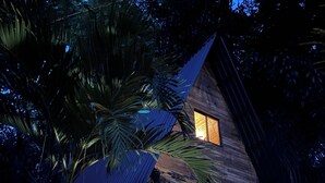 A wooden house with a thatched roof, surrounded by tropical plants. - Buena Onda - Bungalow Hermosa few steps to the beach (Playa Hermosa)