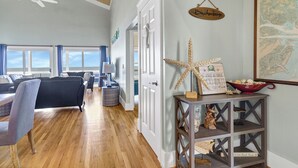 Ein geräumiges Wohnzimmer mit großem Fenster, Deckenventilator und Holzboden.