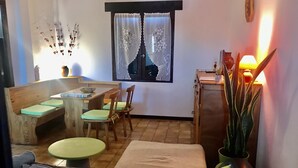 Une pièce chaleureuse avec une table à manger, des chaises, un banc et un canapé.