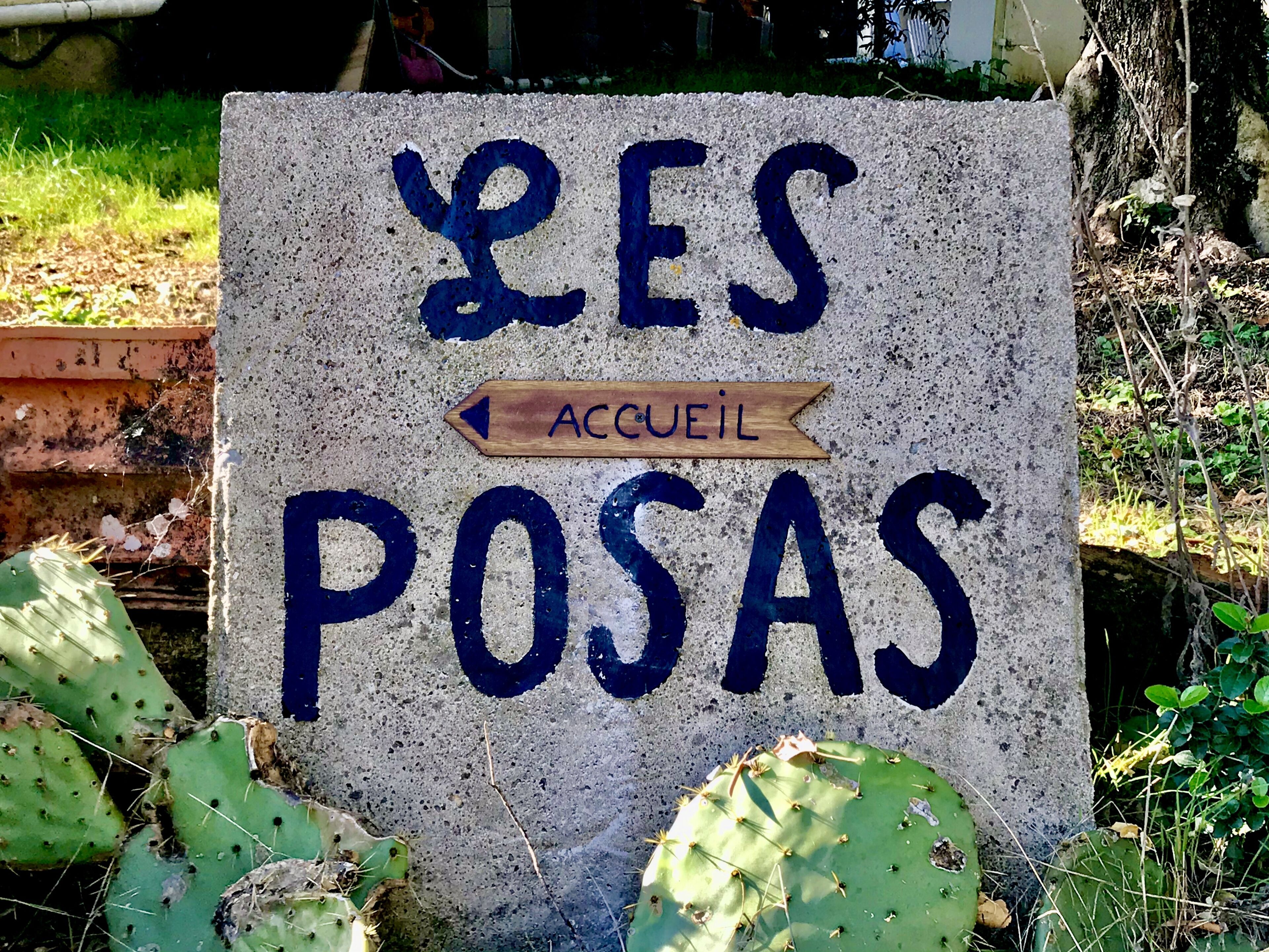 Una señal con el texto 'YES POSAS ACCUEIL' y una flecha señalando a la izquierda.