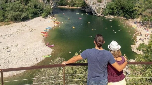 Une formation rocheuse naturelle, avec une rivière et des bateaux.
