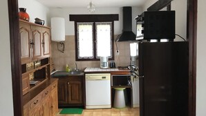 Une cuisine avec des meubles de rangement en bois, un lave-vaisselle, un réfrigérateur et un four à micro-ondes.