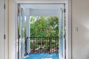 Enter a serene oasis with a covered porch and lush surroundings.