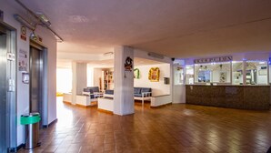 Un'ampia hall con reception, zona salotto e una scala.