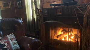 Ein gemütliches Zimmer mit Ledersessel und Kamin.