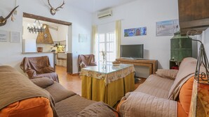 A cozy living room with a sofa set, a coffee table, and a television. - Casa rural Navalonguilla Santa Olalla del Cala by Ruralidays (Huelva)
