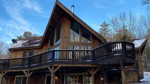 A wooden cabin with a balcony, large windows, and a chimney. - Irish Hill Chalet (West Valley)