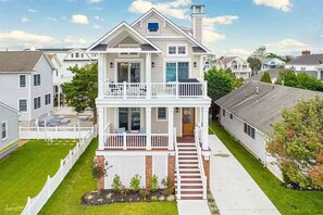 A two-story house with a front porch, a covered entryway, and a visible number '287' on the front. - Beautiful new home, professionally decorated with pool close to town and beach (Avalon)