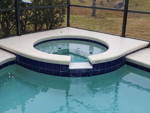 A hot tub with a circular design and a tiled border. - Beautiful Vacation Home, Quiet Neighborhood, Sunny South Facing Pool (Davenport)