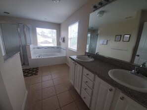 A bathroom with a bathtub, two sinks, and a large mirror. - Beautiful Vacation Home, Quiet Neighborhood, Sunny South Facing Pool (Davenport)