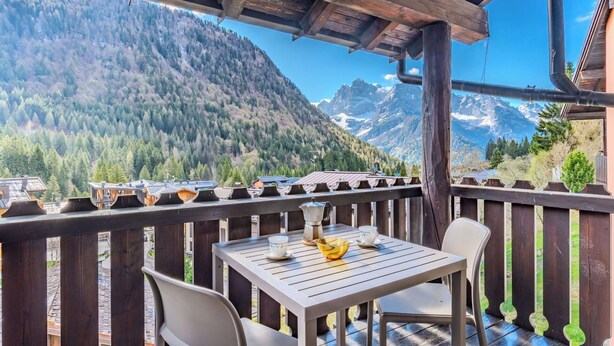 A wooden deck with a table and chairs, overlooking a mountainous landscape. - Lovely apartment for 5 guests with WIFI, TV, balcony and pets allowed (Ragoli)