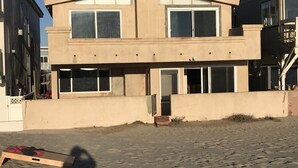 A modern two-story building with large windows and a flat roof. - ON THE SAND! (Oxnard)
