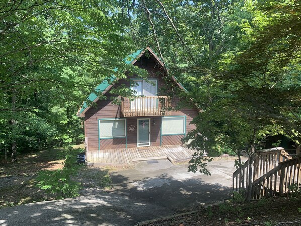 Escape to a secluded cabin nestled in the woods, surrounded by dense forest.