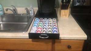 A kitchen with a Keurig coffee maker, a sink, and a drawer with coffee pods. - Home Away From Home, Newly Renovated Apartment (North Troy)