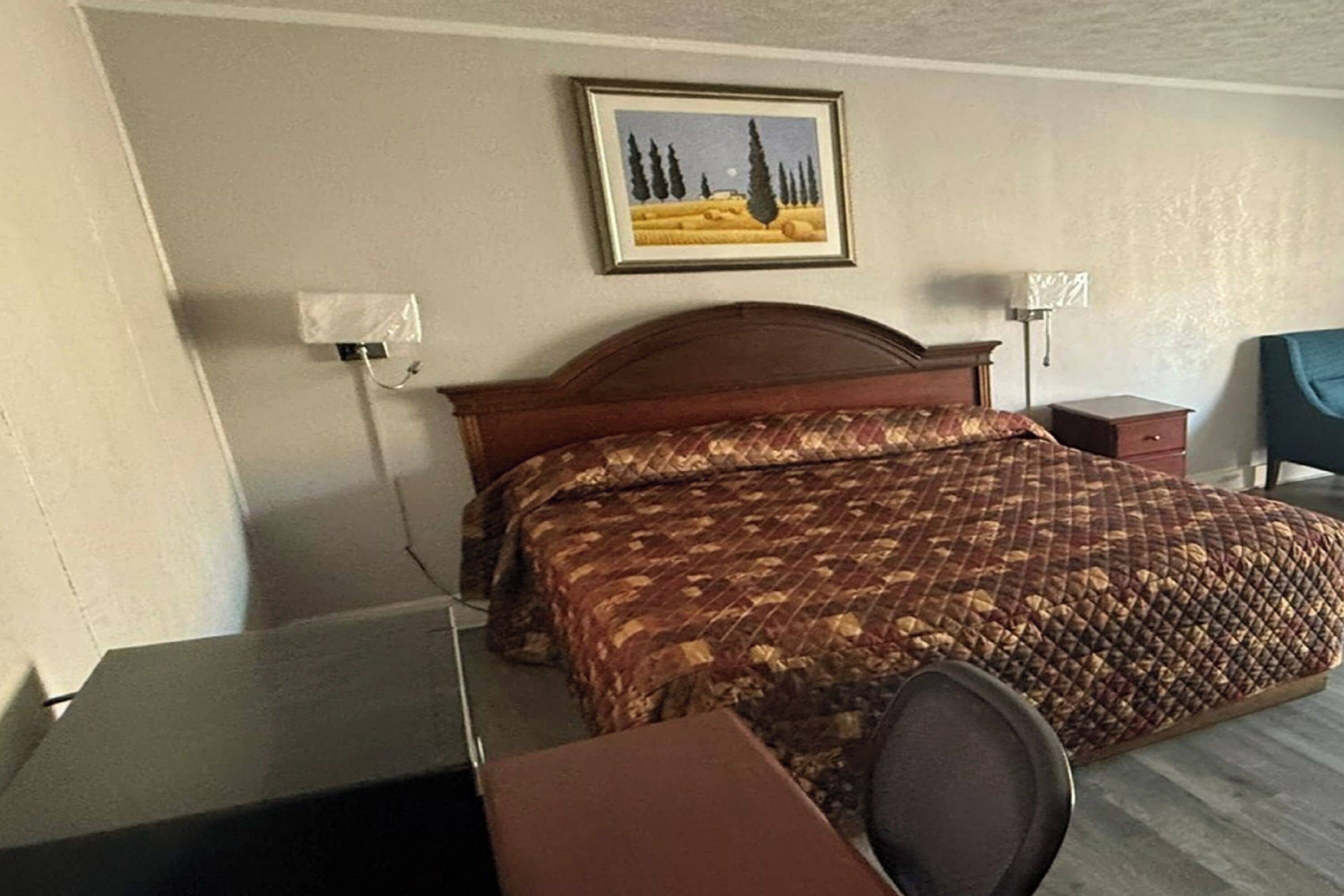 Quarto de hotel com uma cama, uma mesa e uma cadeira.