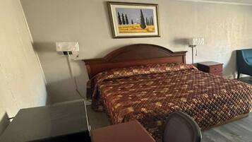 Quarto de hotel com uma cama, uma mesa e uma cadeira.
