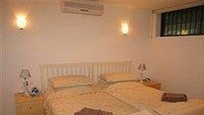 Un dormitorio con cama, mesitas de noche y lámparas de pared.