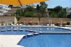 A swimming pool with steps leading into it, surrounded by lounge chairs and umbrellas. - Ra111 Puerto Portals (Calvia)