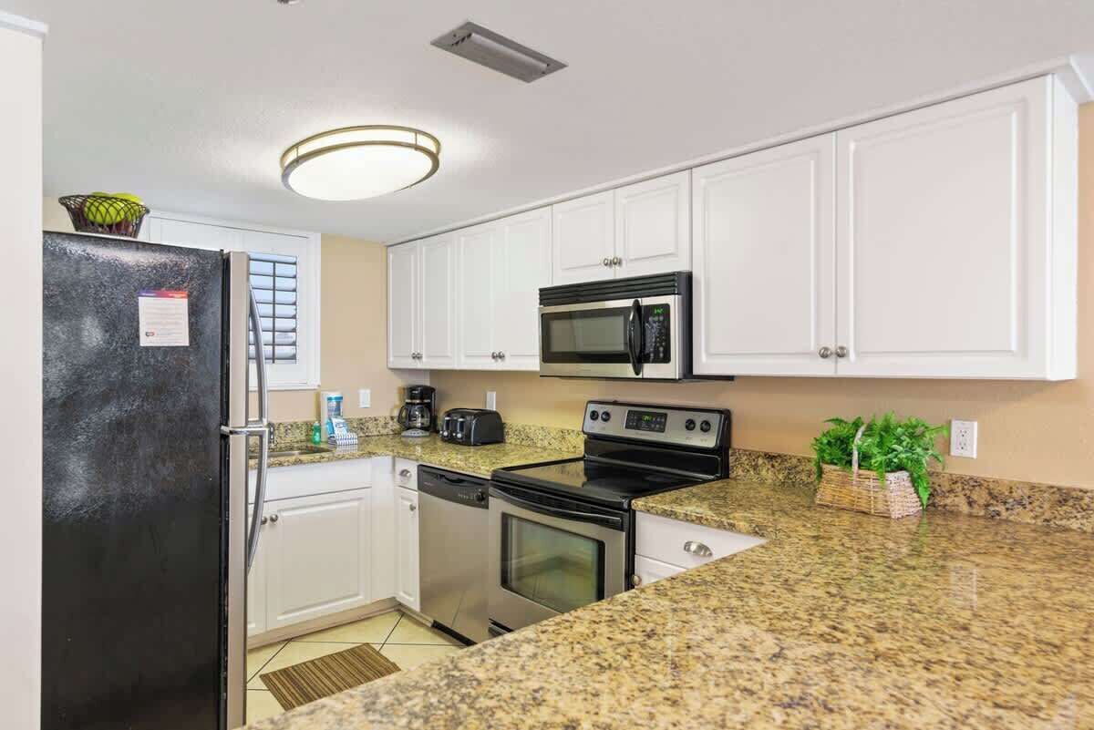 A kitchen with white cabinets, a black refrigerator, a microwave, an oven, and a dishwasher.