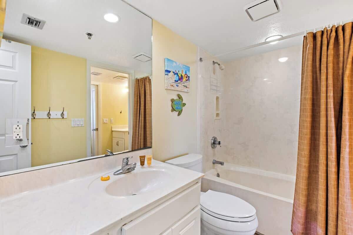 Een badkamer met een wit wastafel, toilet en douche.
