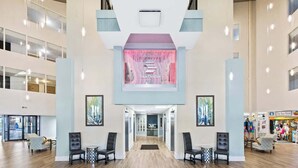 A spacious lobby with a central reception desk, multiple seating areas, and a view of the Sea Store in the background. - SunDestin 1BR Condo With Spacious Layout and Sleeps 6 - Unit 0314 (Destin)
