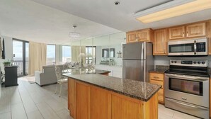 Uma cozinha moderna com bancadas de granito, eletrodomésticos de aço inoxidável e armários de madeira.