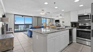A modern kitchen with a central island, built-in appliances, and a view to the outside. - SunDestin Resort Unit 1510 (Destin)