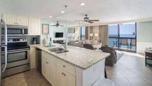 Una cocina moderna con encimeras de granito, electrodomésticos de acero inoxidable y una isla grande.