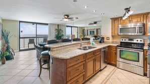 A spacious kitchen with granite countertops, stainless steel appliances, and wooden cabinets. - SunDestin Resort Unit 0808 (Destin)