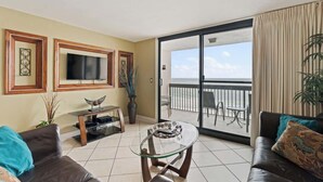 A living room with a glass coffee table, two sofas, a TV, and a balcony with a view. - SunDestin Resort Unit 0808 (Destin)
