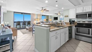 A modern kitchen with a central island, white cabinetry, and stainless steel appliances. - 1BR Gulf-Front Condo With Balcony, Bunks and Sleeps 6 in Destin (Destin)