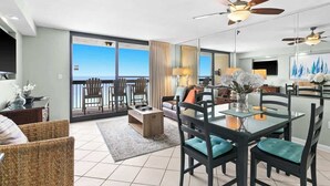A spacious living area with a balcony, a dining table with chairs, and a sofa. - 1BR Gulf-Front Condo With Balcony, Bunks and Sleeps 6 in Destin (Destin)