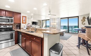 A modern kitchen with granite countertops, stainless steel appliances, and a large island.