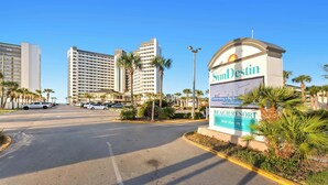 A beach resort sign with palm trees and a clear sky. - SunDestin Resort Unit 1509 (Destin)