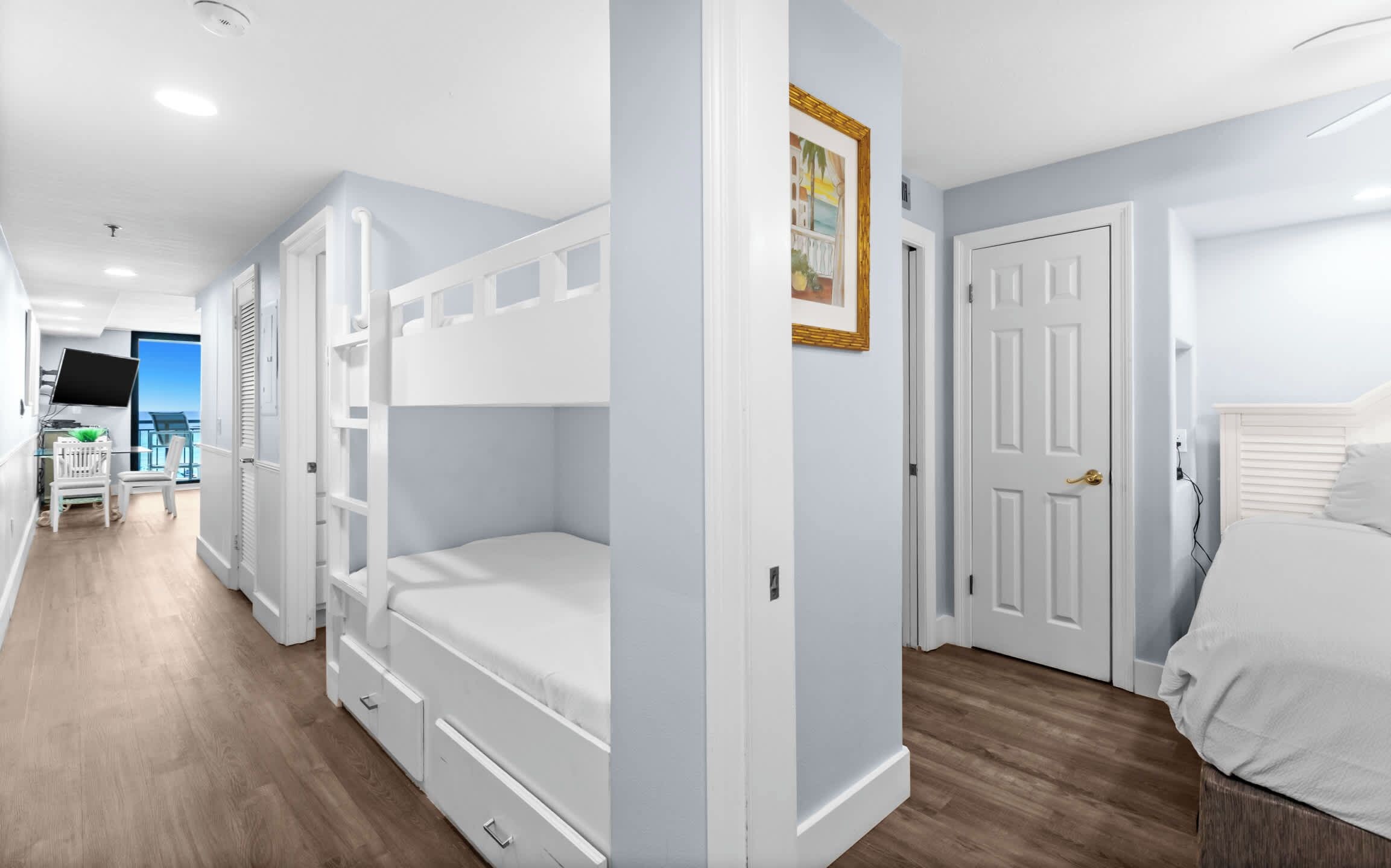 A bedroom with bunk beds, a desk, and a chair.