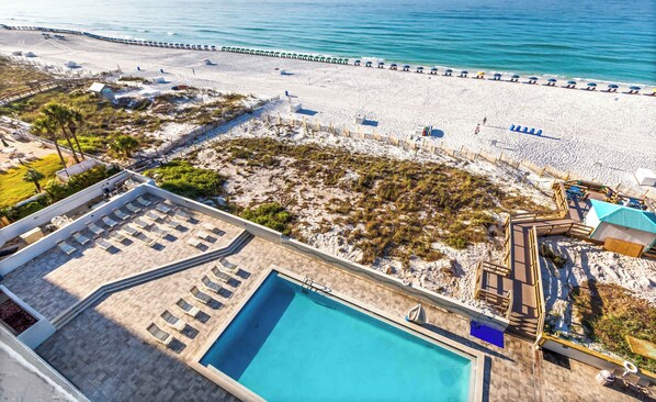 A resort with a swimming pool, beach access, and a view of the ocean.