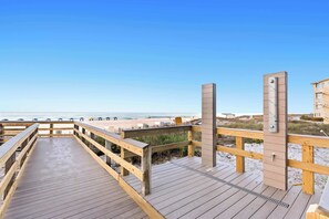A wooden boardwalk leading to a beach with a clear sky. - 1BR Beachfront Living with Unforgettable Gulf Scenery (Destin)