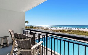 A balcony with a pool, beach view, and two chairs. - SunDestin Resort Unit 0204 (Destin)