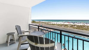 Un balcone con piscina, vista sulla spiaggia e area salotto esterna.