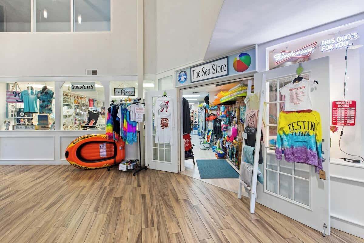 Kaupassa on kyltti, jossa lukee ”The Sea Store”, ja toinen kyltti, jossa mainostetaan ”Destin Florida” -aiheisia t-paitoja.