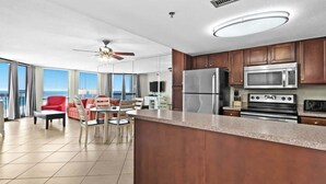 Una cocina moderna con una isla grande, electrodomésticos de acero inoxidable y vistas al océano.