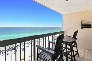 A balcony with a view of the beach and ocean.