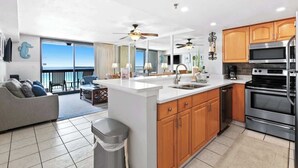 A modern kitchen with a central island, stainless steel appliances, and wooden cabinets. - SunDestin Resort Unit 0710 (Destin)