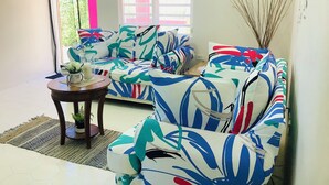 Un salon avec un canapé et une petite table sur laquelle est posée une plante.