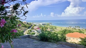 Une vue sur la côte, avec une zone pavée, des bâtiments et une plage.