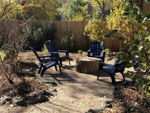 Un espace extérieur aménagé avec quatre chaises bleu foncé et une table ronde en bois.