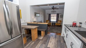 Eine kompakte Küche mit einem Edelstahl-Kühlschrank, einer Holzausziehtisch und modernen Geräten.