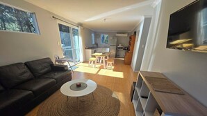 A modern living room with a black leather sofa, a white coffee table, and a wooden floor. - A beautiful chalet in a secluded bush environment, only a short walk to town. (Denmark)