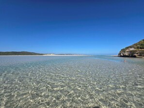 Una vista chiara sulla costa, con spiaggia sabbiosa e scogliere rocciose.